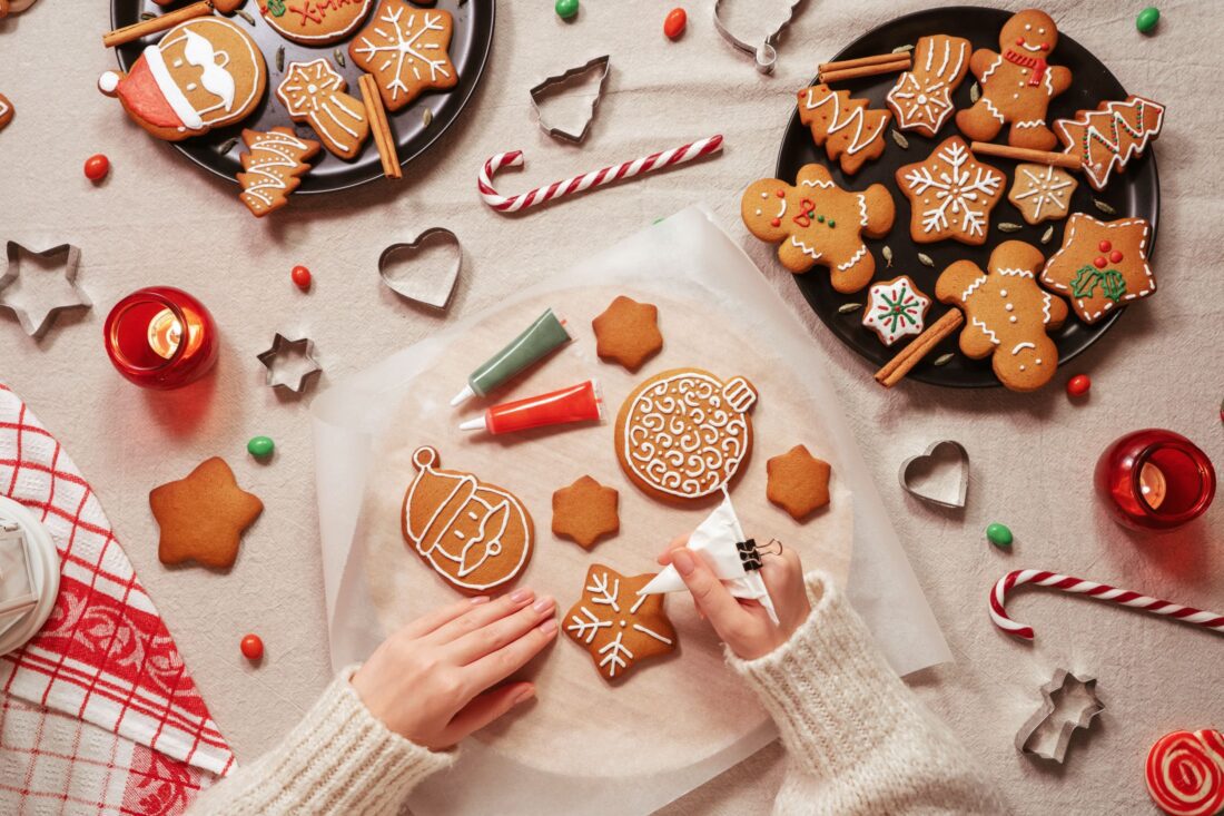 Pessoa decorando biscoitos para o natal.